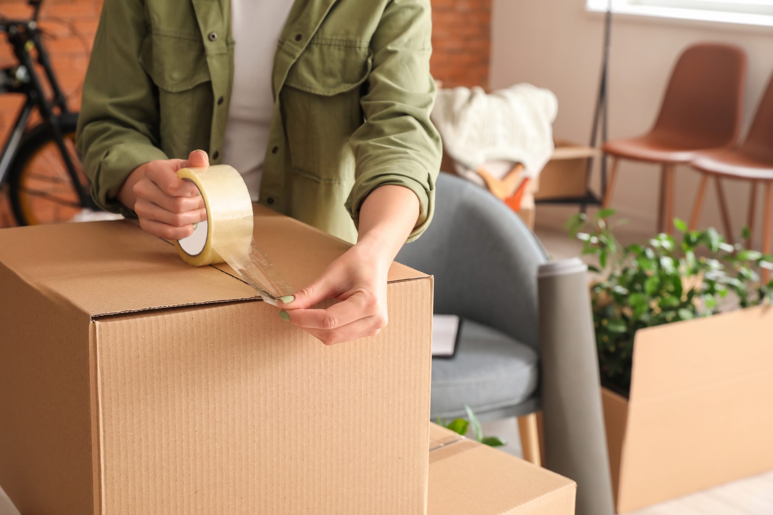 Femme emballant la boîte de déménagement à la maison