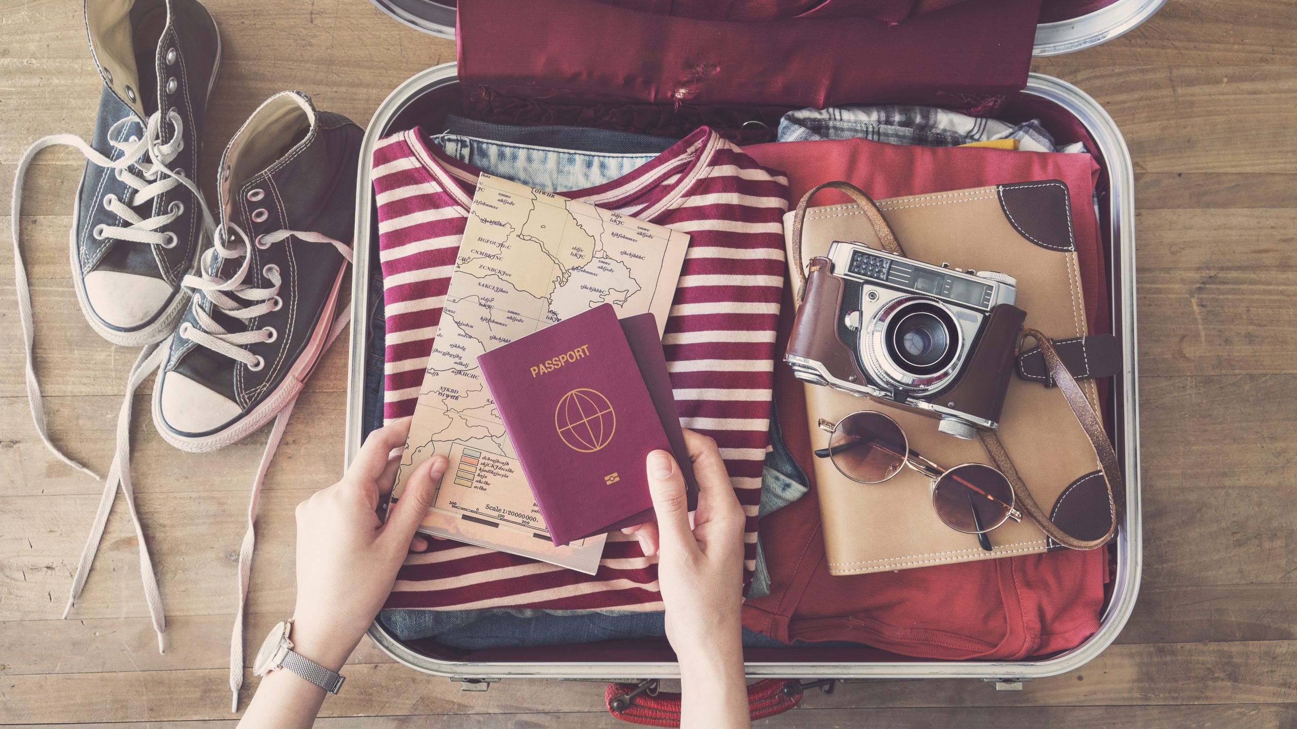 Valise de voyage avec des vêtements, un passeport et un appareil photo