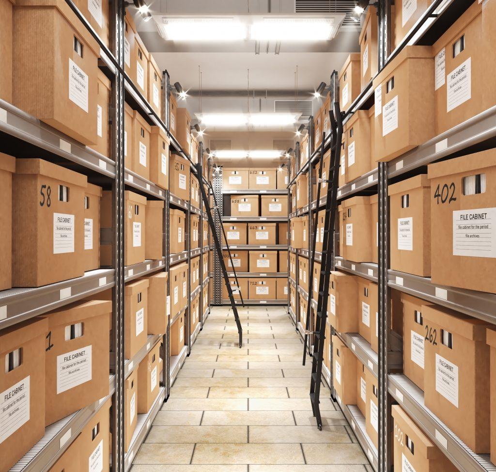 Salle d'archives avec plusieurs boîtes entreposé sur de hautes étagères